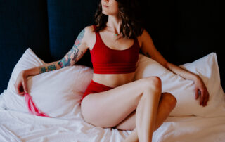 Rae Kennedy wears red lingerie on her bed