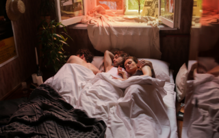 A non-monogamous trio in bed together showing that relationship jealousy is something that everyone can manage